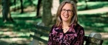 Smiling woman sitting on a park bench outside