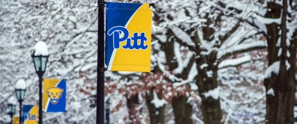 campus in winter with Pitt flags