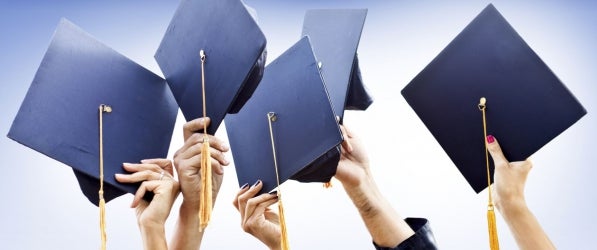 hands in the air holding mortarboards, raised in celebration hands in the air holding mortarboards, raised in celebration