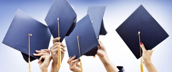 hands holding mortarboards, raised in celebration hands holding mortarboards, raised in celebration