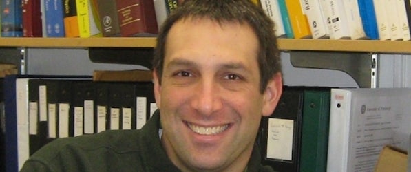 Adam Leibovich in his office against a backdrop of books